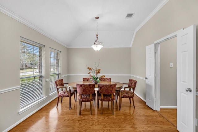 dining area with lofted ceiling, visible vents, crown molding, and light wood-style flooring