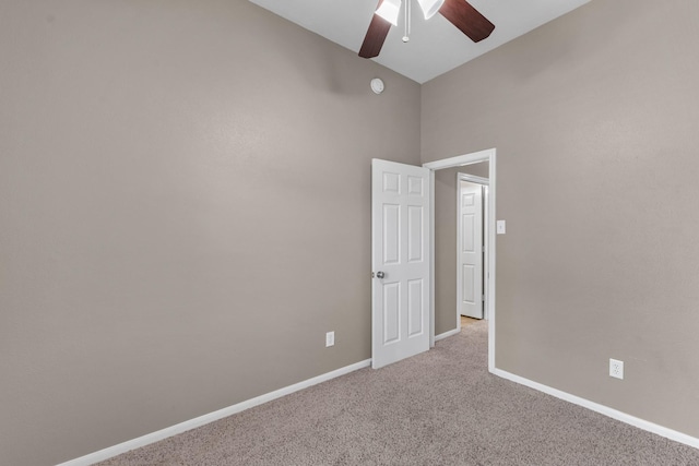 spare room featuring ceiling fan, baseboards, and light colored carpet