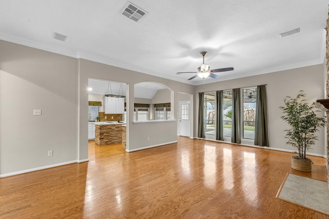 unfurnished living room featuring light wood-style flooring, visible vents, ceiling fan, and baseboards