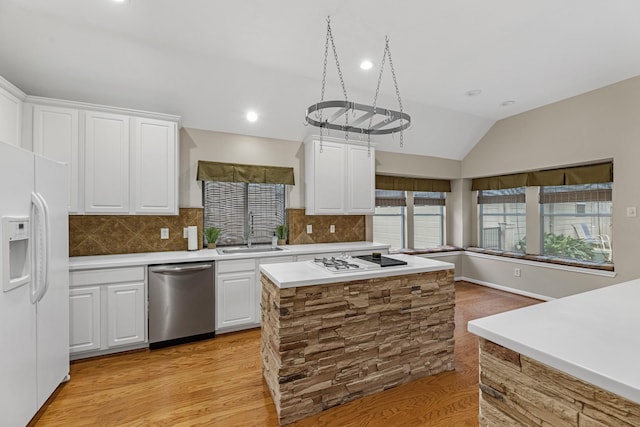 kitchen with white appliances, light countertops, a sink, and white cabinetry