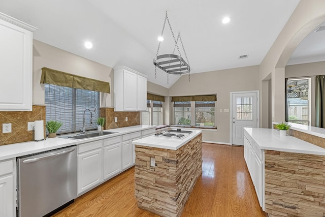 kitchen featuring light countertops, white cabinetry, a kitchen island, a sink, and dishwasher