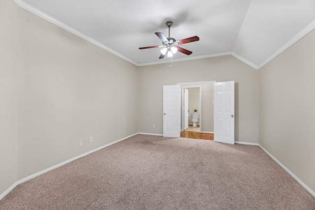 unfurnished bedroom featuring lofted ceiling, carpet, ornamental molding, and baseboards