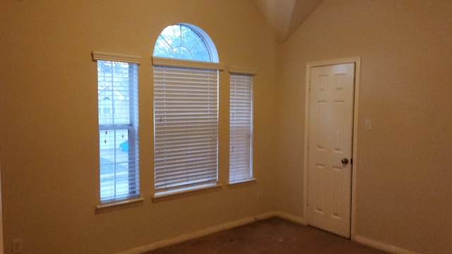 unfurnished room featuring vaulted ceiling