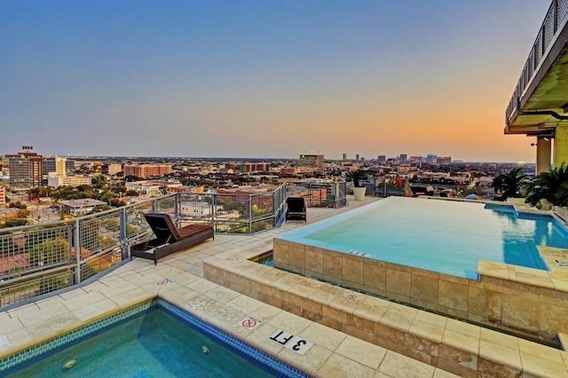 pool at dusk featuring a city view