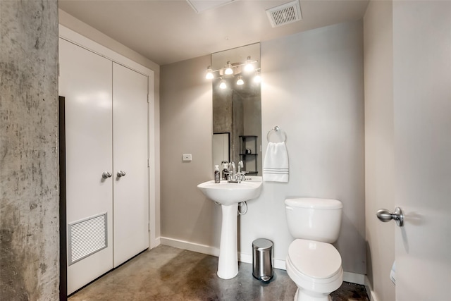 half bath featuring visible vents, concrete floors, toilet, and baseboards