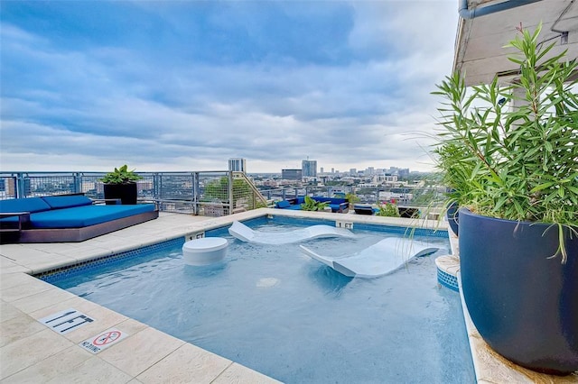 view of swimming pool featuring a city view and a hot tub