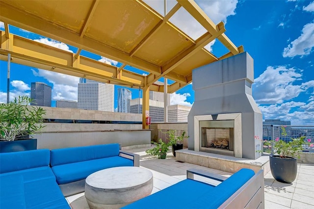 view of patio with a city view and an outdoor living space with a fireplace