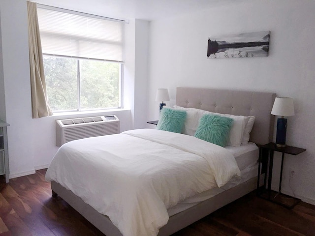 bedroom featuring dark wood-type flooring and a wall unit AC