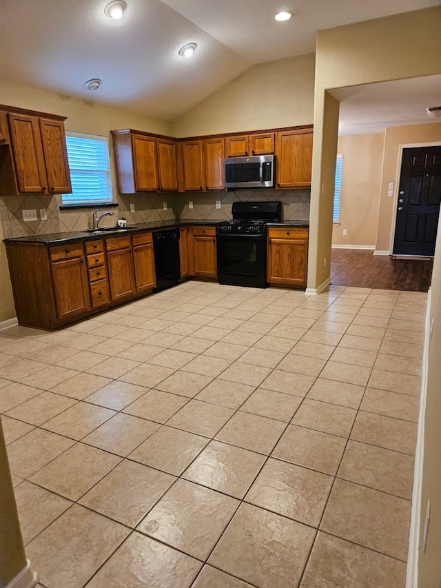 kitchen with lofted ceiling, sink, tasteful backsplash, black appliances, and light tile patterned flooring