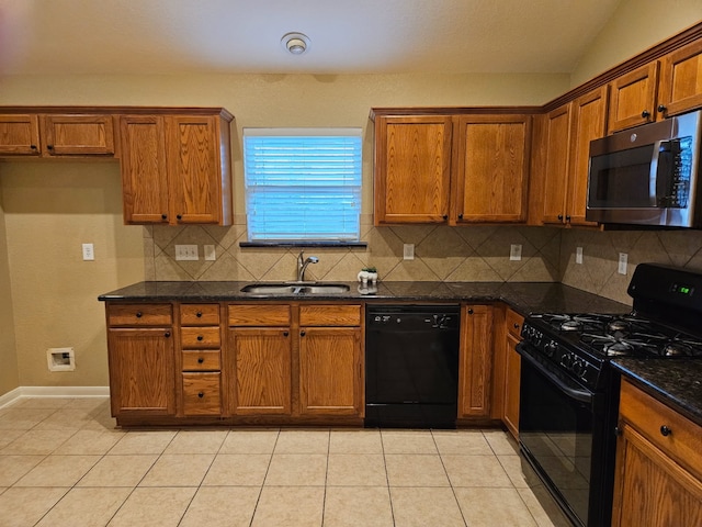 kitchen with sink, light tile patterned floors, dark stone counters, decorative backsplash, and black appliances