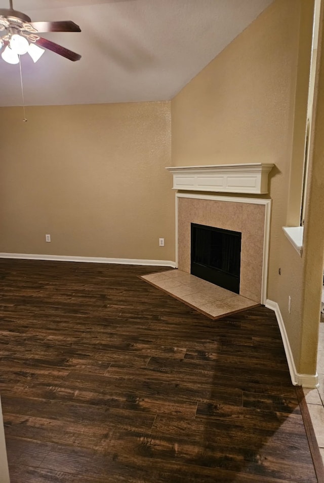 unfurnished living room featuring vaulted ceiling, dark hardwood / wood-style floors, ceiling fan, and a fireplace