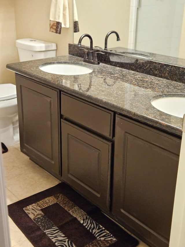 bathroom featuring tile patterned flooring, vanity, and toilet