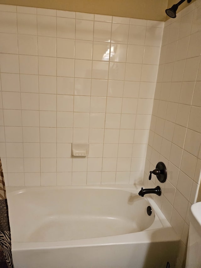 bathroom featuring shower / bathtub combination with curtain and toilet