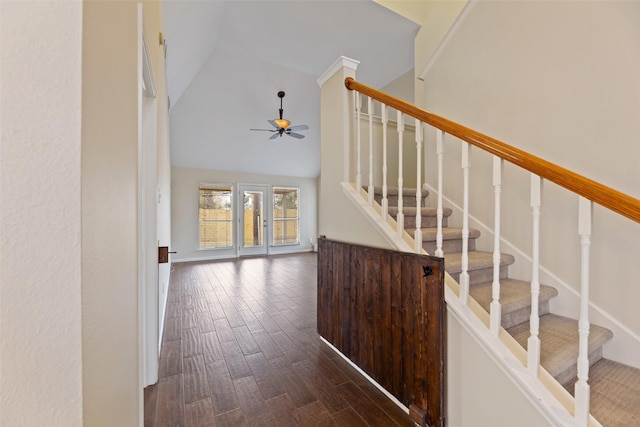 stairway with ceiling fan, high vaulted ceiling, and wood finished floors