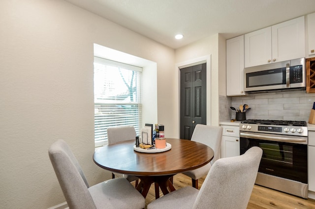 dining space featuring recessed lighting and light wood-style floors