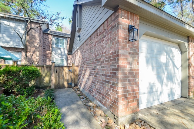 view of property exterior featuring brick siding and fence