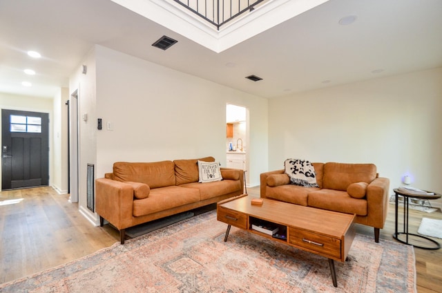 living room with visible vents, light wood-style flooring, and recessed lighting