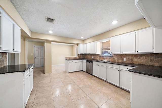 kitchen featuring tasteful backsplash, white cabinetry, a sink, and stainless steel dishwasher