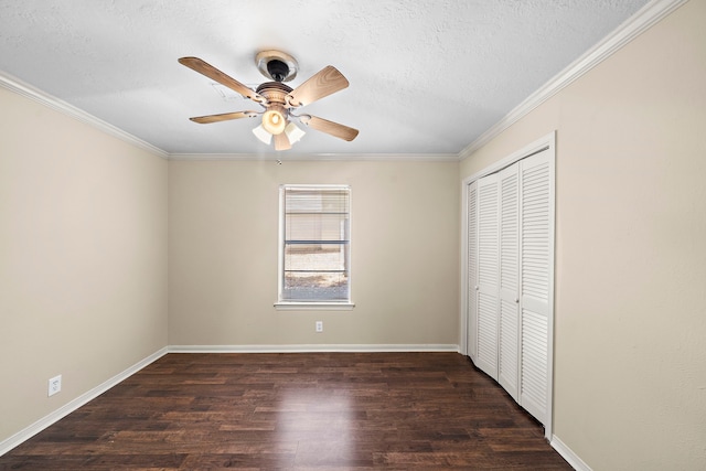 unfurnished bedroom featuring crown molding, a textured ceiling, dark wood finished floors, and a closet