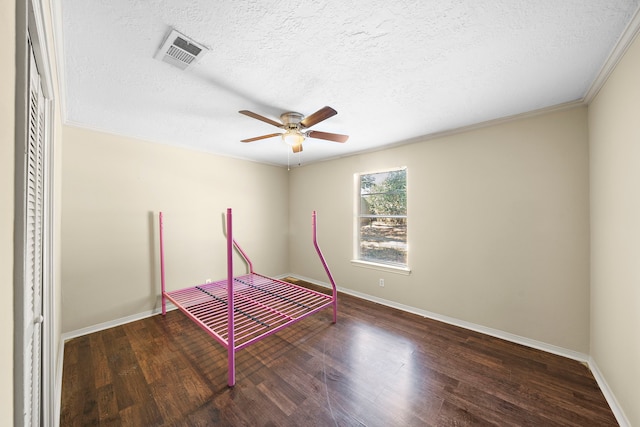 unfurnished bedroom featuring a textured ceiling, wood finished floors, visible vents, and baseboards