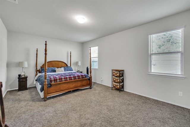 bedroom featuring dark carpet and baseboards