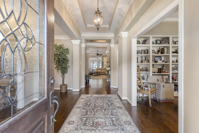 foyer with ornate columns, ornamental molding, dark hardwood / wood-style floors, and ceiling fan with notable chandelier