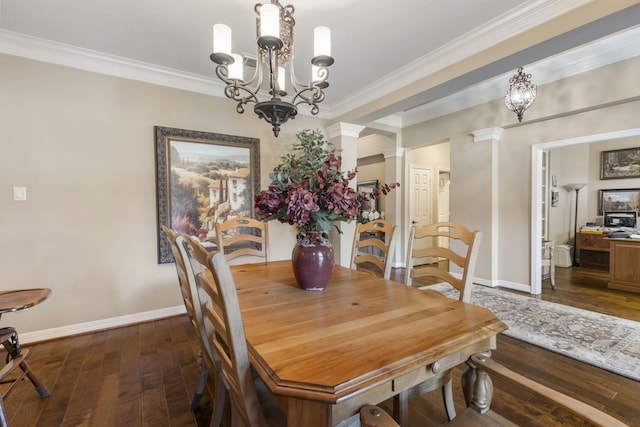 dining area with ornate columns, ornamental molding, dark hardwood / wood-style floors, and an inviting chandelier