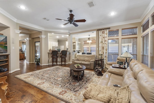 living room featuring crown molding, ceiling fan, dark hardwood / wood-style flooring, and ornate columns