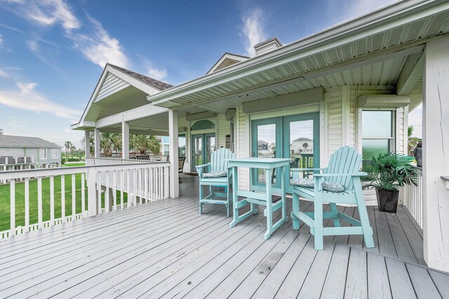 wooden terrace with french doors and a yard