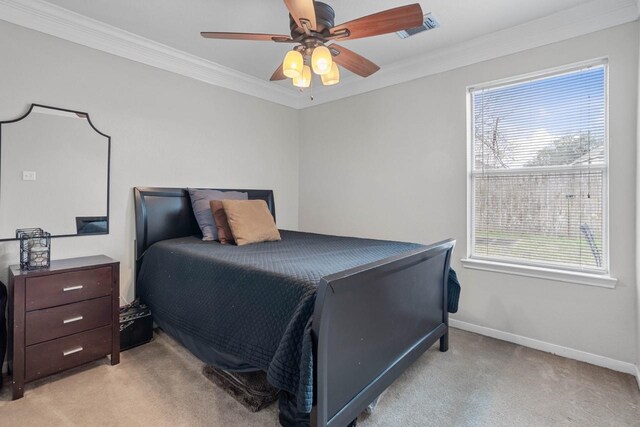 carpeted bedroom with ornamental molding and ceiling fan