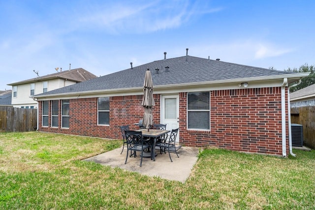 back of property with central AC, a patio area, and a lawn