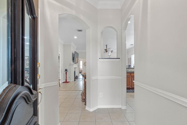 interior space featuring light tile patterned floors and crown molding