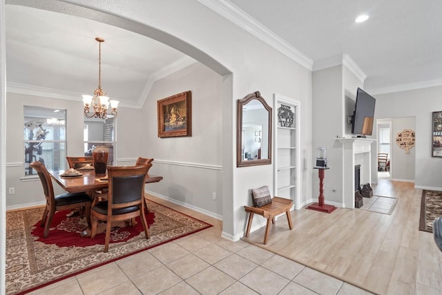 dining area featuring a notable chandelier, ornamental molding, light tile patterned flooring, and lofted ceiling