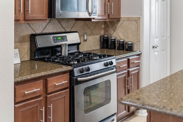 kitchen featuring appliances with stainless steel finishes, dark stone countertops, and tasteful backsplash