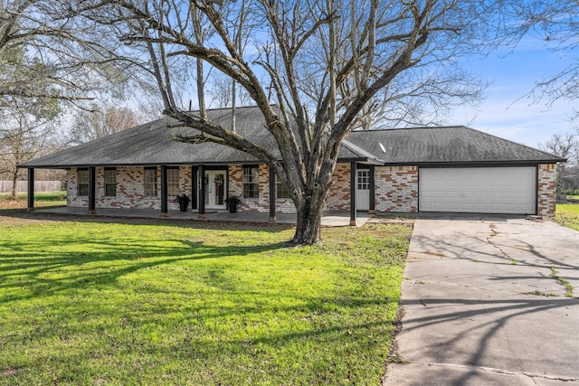 ranch-style home featuring a garage, covered porch, and a front lawn