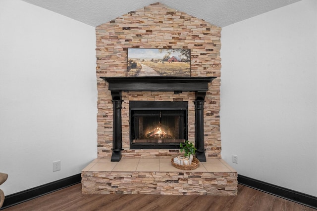 interior details featuring hardwood / wood-style flooring, a large fireplace, and a textured ceiling