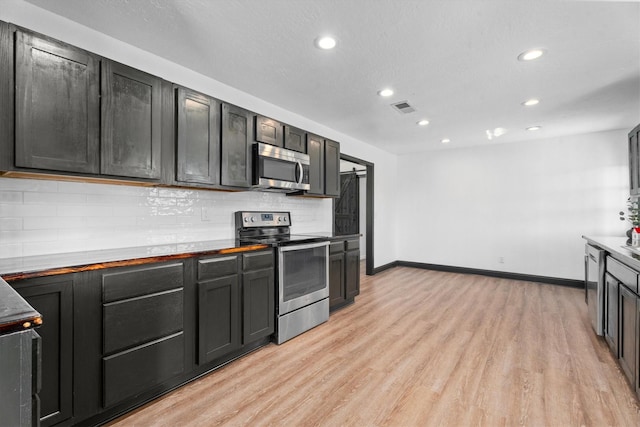 kitchen featuring tasteful backsplash, stainless steel appliances, and light hardwood / wood-style floors