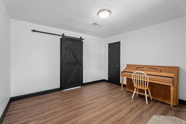 office space with a barn door and hardwood / wood-style floors