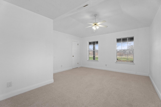 empty room with lofted ceiling, ceiling fan, and light colored carpet