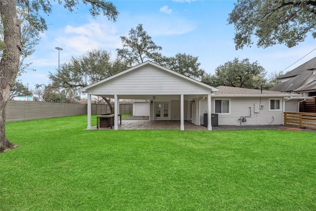 rear view of property featuring a patio, central AC, and a lawn