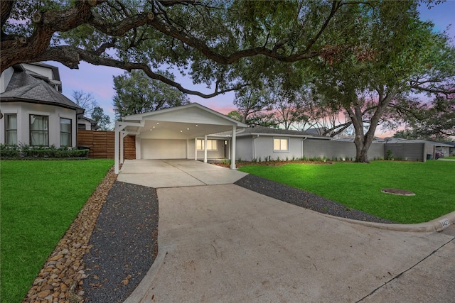 ranch-style home featuring a carport and a yard