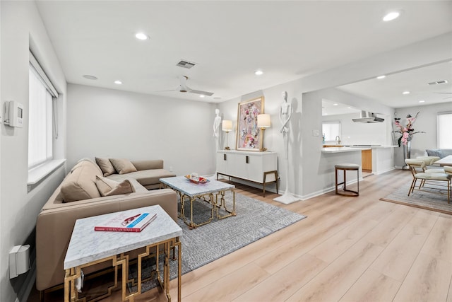 living room with sink and light hardwood / wood-style floors