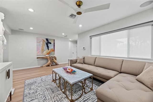 living room featuring light hardwood / wood-style flooring and ceiling fan