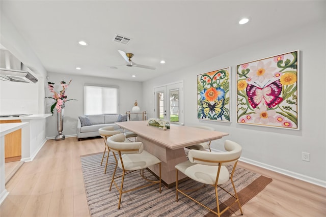 dining space with light hardwood / wood-style floors and french doors