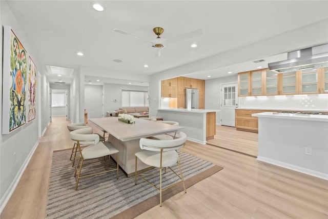 dining room with ceiling fan and light hardwood / wood-style floors