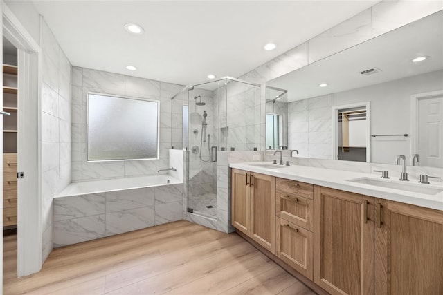 bathroom featuring vanity, plus walk in shower, hardwood / wood-style floors, and tile walls