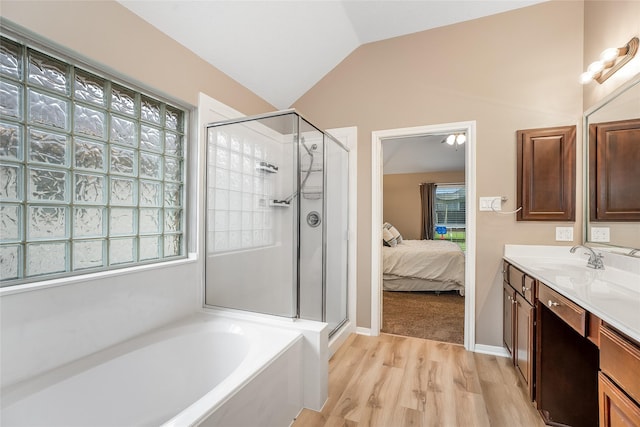 bathroom featuring hardwood / wood-style flooring, plus walk in shower, vanity, and lofted ceiling