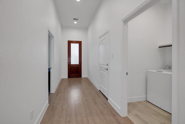 doorway to outside with washer / clothes dryer and light wood-type flooring