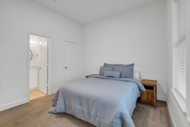 carpeted bedroom featuring ensuite bath