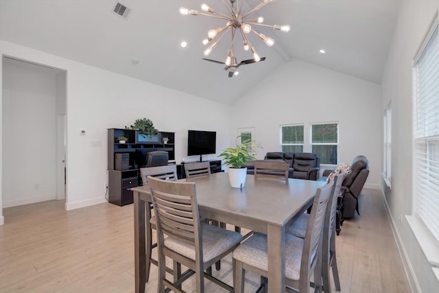 dining room featuring an inviting chandelier, plenty of natural light, high vaulted ceiling, and light hardwood / wood-style flooring